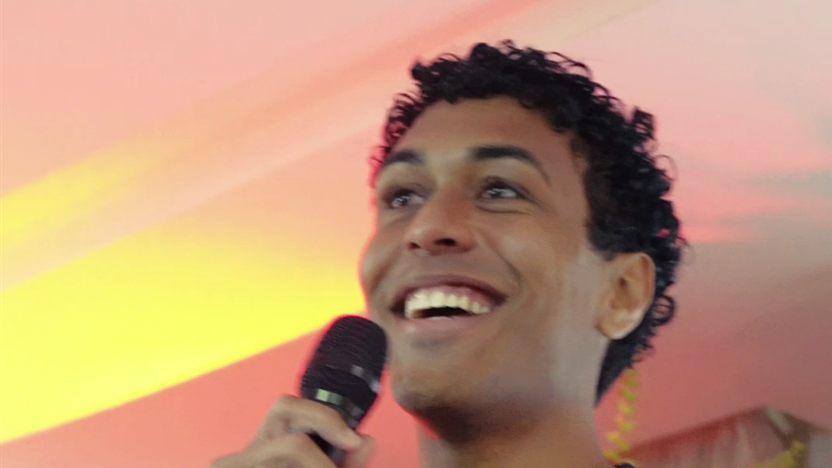 Participante rindo ao microfone no VX 2026 da Villa Camarão